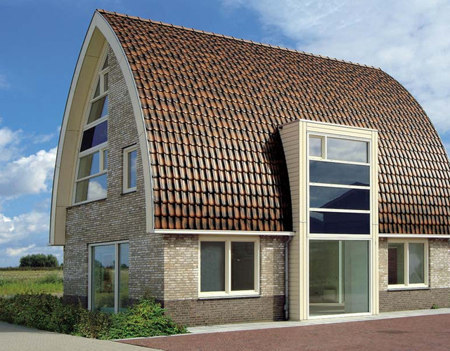 A single-family house covered with shaded copper brown Flandern tiles